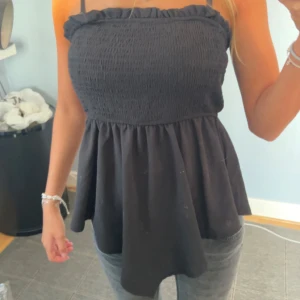 Svart smockad top inga axelband. - XS/S