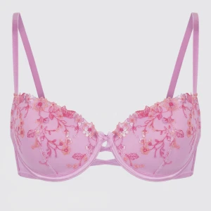 Rosa broderad hunke Möller bh - Säljer en söt rosa balconette-bh med tunna axelband och vackra broderade blommor i rosa och orange. Bh:n har spetsdetaljer längs kanten och en liten öppning framtill. Slutsåld och kommer inte in igen. Använd endast en gång. Nypris 600kr