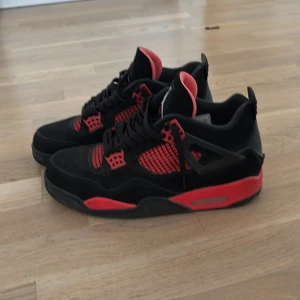 Svarta och röda Nike Air Jordans - Säljer ett par svarta och röda Nike Air Jordans med klassisk Jumpman-logga på plösen. Skorna har svarta snören, röda detaljer och meshpaneler på sidorna. Perfekta för dig som vill sticka ut med en ikonisk sneaker.