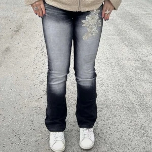 Svarta jeans med blommig silverdetalj - As snygga svarta jeans med silvriga blomdetaljer. Bilderna är på gamla säljaren då byxorna tyvärr inte riktigt passade mig. Priset kan såklart diskuteras 💕                     Midjemått: Ca 35-36 cm, dem är lite strechiga.                                                              Innerbenslängd: Ca 80 cm 
