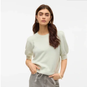 Ljusgrön stickad tröja med puffärm - Superfin ljusgrön stickad tröja med korta puffärmar och rund halsringning. Tröjan har en mjuk och mysig känsla och är perfekt för lager-på-lager. Enkel och stilren design som passar till mycket.