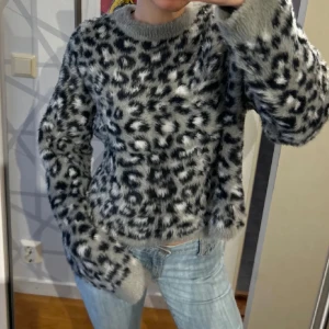 Grå leopardmönstrad tröja - Supermjuk och fluffig tröja i grått med svart leopardmönster. Rund halsringning och långa ärmar med ribbade muddar.💕