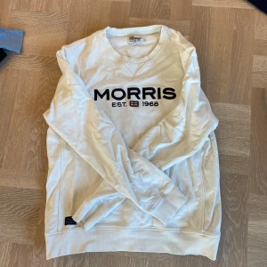 Vit tröja från Morris - Säljer en stilren vit tröja från Morris med tryck 'Morris EST. 1968' på bröstet. Tröjan har långa ärmar och en rund halsringning. Perfekt för en avslappnad stil. Använd en del, skrynklig men den kommer såklart att strykas innan den skickas👍 Storlek M, något kort på mig som är 183 så den passar dig som är runt 175 o några centimeter uppåt. Vid frågor är det bara att höra av sig, svarar på allt! Pris ej hugget i sten, tar bud.