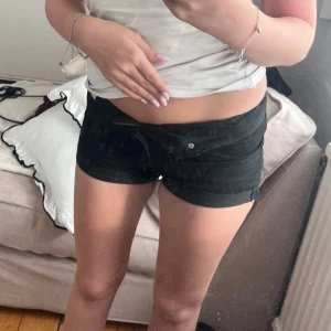 Svarta shorts från H&M Divided - Snygga svarta shorts från H&M Divided. De är korta och har en knapp och dragkedja framtill. Perfekta för varma sommardagar.