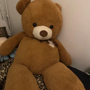 Stor brun nallebjörn - Säljer en stor och gosig brun nallebjörn med ett hjärta på bröstet där det står 'Love'. Perfekt som present eller mysig inredningsdetalj i sovrummet. Nallen är ca 160 cm lång! Eftersom det är svårt att leverera denna så möts jag upp i Göteborg för att lämna den! Skriv för fler frågor ❤️