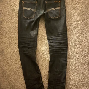Riktgt feta Nudie jeans 😝 - Säljer ett par Nudie selvedge jeans med snygga orangea sömmar som ger en riktigt schysst kontrast. Köpta nya på Samdelins för ca 1 500 kr, mitt pris: 799 kr.  Säljer dem eftersom jag vill testa en annan modell. Kan även tänka mig ett byte mot andra Nudie selvedge jeans – kom med förslag, men inget som sitter som korvskinn på benen!  Pris kan diskuteras. Har du frågor? Hör av dig så tar vi en frågestund när det passar!                          Denna text är absoluta inte skriven av chat gpt👍