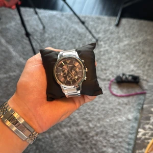 Emporio Armani Klocka - En klocka av märket Emporio Armani i nyskick, väldigt sparsamt andvänd, silver länk och ett mörkblått klockur 