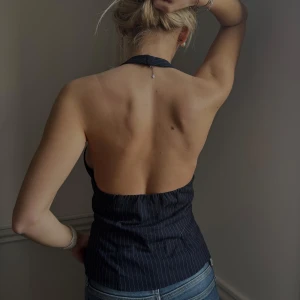 Svart randig halterneck topp - Snygg svart halterneck topp med vita ränder och djup urringning i ryggen. Perfekt för en kväll ute! Köpt vintage så vet ej märke , storleken xs 