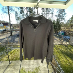 Half zip tröja - Snygg svart långärmad tröja från Weekday med dragkedja vid halsen. Perfekt för en stilren look. Passar bra till både jeans och chinos.