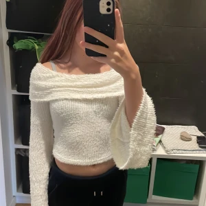 Vit offshoulder tröja - Säljer en superfin vit offshoulder tröja med långa ärmar och en croppad passform. Perfekt för en stilren look. Tröjan är mjuk och bekväm, idealisk för både vardag och speciella tillfällen.