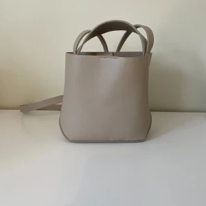 Arket liknande väska från Gina - Elegant beige handväska med stilren design. Väskan har dubbla handtag och en dragkedja. Skriv för frågor eller fler bilder💗💗