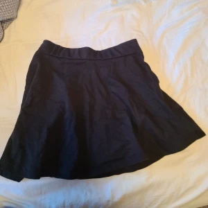 Svart kjol från KappAhl - Säljer en svart kjol från KappAhl i storlek 152 men passar mig som 164. Kjolen har en enkel och stilren design med en elastisk midja för extra komfort. Perfekt för olika tillfällen och lätt att matcha med olika toppar.