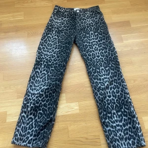 Leopardmönstrade byxor från Neo Noir - Snygga leopardmönstrade byxor från Neo Noir i en mix av bomull och återvunnen bomull. Byxorna har en rak passform och är perfekta för att ge din outfit en djärv touch. Byxorna är i fint skick. Rökfritt hem. Skickar paket som spårbart. Nypris 999kr. 