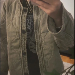 Grön zara jacka - Säljer en olivgrön quiltad jacka med knappar framtill. Jackan har en rund halsringning och långa ärmar, perfekt för höst och vår. Den quiltade designen ger en stilren look. (Första bilden är lånad!!)