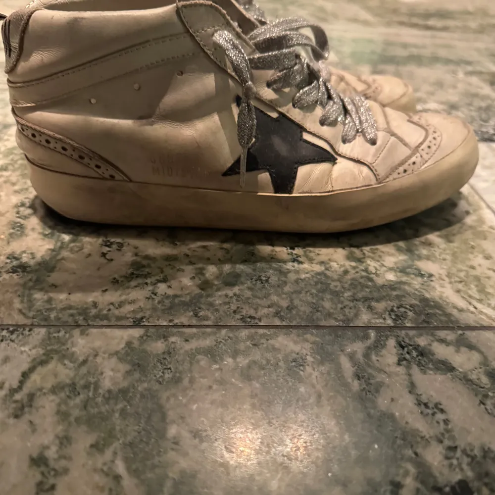 Snygga sneakers från Golden Goose med en stjärna på sidan och glittriga snören. Skorna har en unik design med perforerade detaljer och en bekväm passform. Knappt använda och säljer till bra pris, kostar egentligen runt 5000 kr. . Kengät.