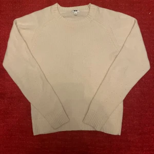 Stickad tröja  - Säljer denna snygga stickade tröja från uniqlo. Den är i 100% ull och riktig skön för alla tillfällen. Den är i en off white/beige färg. Tröjan är enbart använd ett fåtal gånger vilket gör att skicket är väldigt bra. 