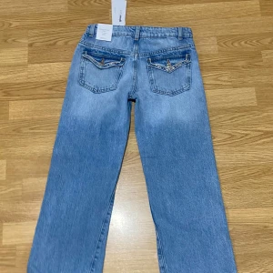 Blå jeans med broderade bakfickor - Snygga blå jeans från gina med broderade detaljer på bakfickorna. Aldrig använda och bara testade, var för små för min lillasyster storlek 152. Pris kan diskuteras vid snabb affär💗
