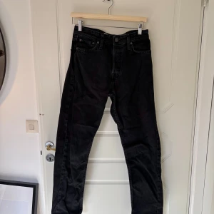 Svarta jeans från Jack & Jones - Snygga svarta jeans från Jack & Jones. De har en knappgylf och är tillverkade i bomull för en bekväm passform. 