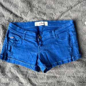 Blå lågmidja jeansshorts från Hollister - Snygga lådmidja blå jeansshorts från Hollister med . Midjan är w26 eller storlek XS/S. 