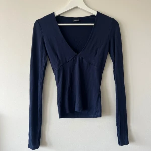Marinblå topp från Gina Tricot  - Säljer denna marinblå toppen från Gina tricots ”soft touch” kollektion. Den är urringad och har tumvantar, använd 2 ggr🥰
