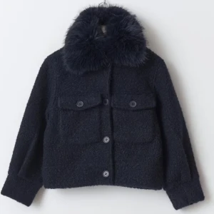 Mörkblå teddyjacka med pälsdetalj - Säljer en stilren mörkblå teddyjacka med en mjuk pälsdetalj på kragen från ginatricot young. Jackan har knappar framtill och två stora fickor på bröstet, nyskick, säljer då jag tycker den är för kort på mig!