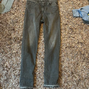 Grå jeans från Replay - Snygga grå jeans från Replay med en klassisk design. De har en knapp och dragkedja framtill samt fem fickor. Perfekta för en stilren look.