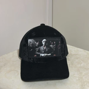 Svart grisch keps - Snygg svart keps med ett coolt tryck på framsidan. Kepsen har ett nätmaterial på sidorna och baksidan för bra ventilation. Perfekt för en avslappnad och Stockholm stil