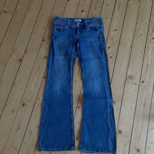 Blå jeans från Gina Tricot - Säljer ett par snygga blå jeans från Gina Tricot i storlek 152. De har en bootcut-stil och är tillverkade i klassiskt jeansmaterial. Perfekta för en avslappnad look. De har ett litet hål på knät. Använt cirka 4-5 gånger, säljer pga har växt hur den 💕