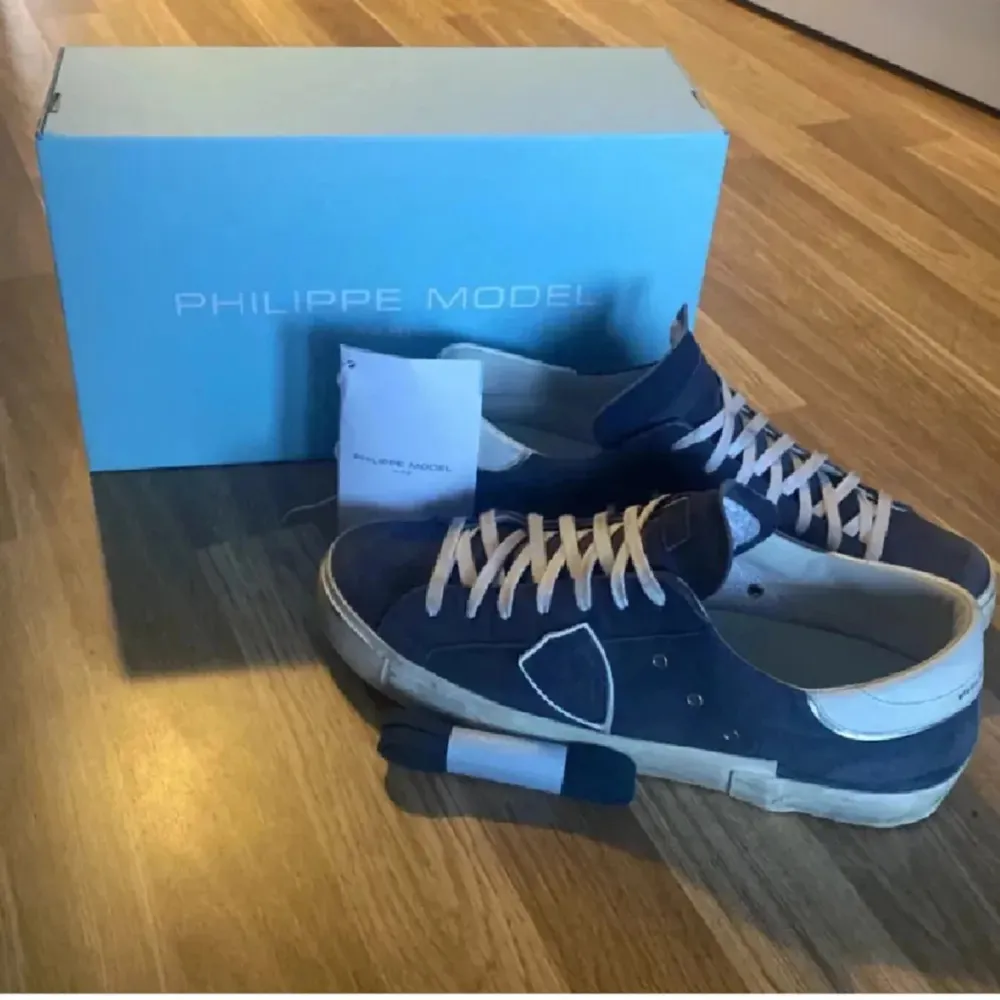 Snygga blå sneakers från Philippe Model i nubuck med vita detaljer och snörning. Skorna har en stilren design med en diskret logotyp på sidan. Perfekta för en avslappnad och trendig look.. Kengät.