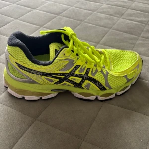 Neongula Asics sneakers - Säljer ett par Asics sneakers i neon-gult med svarta och silvriga detaljer. Skorna har mesh-ovandel för bra andning, snörning och en rejäl, stötdämpande sula. Skriv för fler frågor eller bilder i chatten tack!