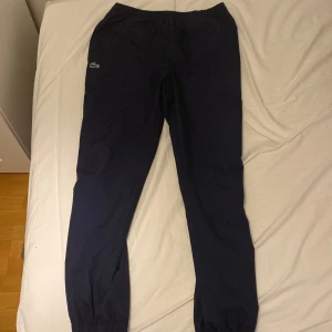 Mörkblå tracksuit byxor Lacoste S -  mörkblå tracksuitbyxor från Lacoste i storlek S originalpris 1200 kr JD sports säljs för 499 kr, pris kan diskuteras. Finns i Sthlm