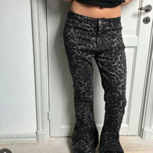 Calzedonia leopard jeans - Säljer ett par svarta jeans från Calzedonia med grått leopardmönster. Byxorna har bootcut-modell och normal passform, med klassisk femficksdesign och dragkedja. Materialet är jeans och de har en snygg, edgy vibe.
