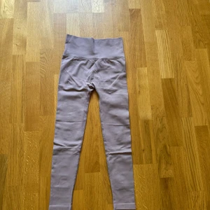 Grå beige seamless leggings med scrunch - Säljer ett grå beige seamless leggings med hög midja och scrunch-detalj bak. De är tighta och stretchiga, perfekta för träning eller chill. Materialet är mjukt och följsamt, och midjan är extra bred för skön passform.