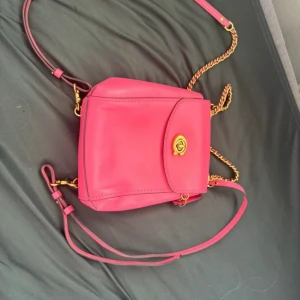Rosa axelväska i skinn från Coach pink - coach parker convertible backpack i rosa färg,tillverkad i läder och praktisk för vardagsbruk. den är helt oanvänd, men lappen sitter ej kvar. 