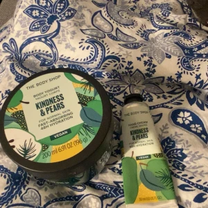 The Body Shop Kindness & Pears duo - Säljer ett set med Body Yogurt (200 ml) och Hand Cream (30 ml) från The Body Shop i doften Kindness & Pears. Båda är veganska och ger 48h återfuktning. Fräscha gröna och gula förpackningar med grafiskt mönster. Perfekt för dig som älskar fruktiga dofter och mjuk hud.