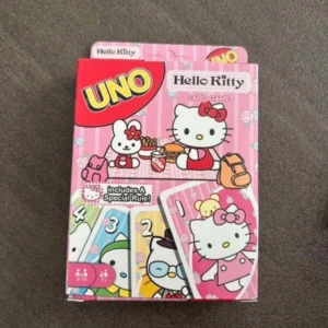 UNO Hello Kitty Card Game - UNO Hello Kitty är en färgglad och söt version av det klassiska kortspelet, perfekt för dig som älskar Hello Kitty! Spela med vänner och familj, samla på unika kort med Hello Kitty-motiv och upptäck en speciell regel. Passar både unga och unga vuxna. Råka köpa två stycken så säljer den andra, de är helt ny och oöppnad 