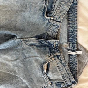 Weekday Arrow ljusblå straight jeans - Ljusblå jeans från Weekday, modell Arrow Low Straight Jeans. Klassisk femficksdesign, raka ben och låg midja. Snyggt tvättad denim med tydliga sömmar och vintagekänsla. Perfekta för en avslappnad och trendig look. Använda bara några få gånger. Nypris: 590kr.