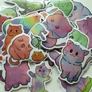 27st Kawaii Galaxy Cats - En samling med söta, färgglada klistermärken föreställande katter i olika poser och uttryck. Perfekt för att dekorera din laptop, mobil eller anteckningsbok och ge din vardag en extra dos cuteness och färg. Passar dig som älskar katter och vill ha något unikt och lekfullt!