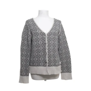 Mönstrad kofta från Odd Molly - Superfin kofta från Odd Molly i svart och vitt med snyggt grafiskt mönster. V-ringad med dekorativa kanter och broderad ros på insidan. Koftan är stickad i mjuk bomull och har långa ärmar samt ribbade muddar och nederkant.