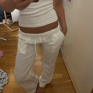 Vita linnebyxor med snörning - Säljer ett par vita linnebyxor med dragsko i midjan och raka ben. Byxorna har två stora fickor framtill och är perfekta för en chill och avslappnad stil. Lätta och luftiga, passar grymt till sommaren.säljer pågrund av att dom börjar bli lite små. Original pris600