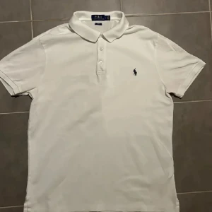 Vit pikétröja från Polo Ralph Lauren - Säljer en vit Ralph Lauren piké i slim fit så har riktigt bra passform. Grymt skick, inga skador eller fläckar.
