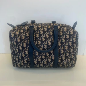 Christian Dior Trotter Speedy 30 handväska - Säljer en klassisk Dior axelväska i blått och beige med ikoniskt monogrammönster. Väskan har rundade former, dubbla handtag i blått skinn och dragkedja upptill. Väldigt fint skick med endast lite fläckar inuti. 