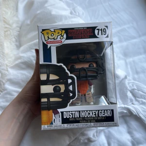 Dustin (Hockey Gear) #719 - Cool Funko Pop! vinylfigur av Dustin i hockeyutrustning från Stranger Things. Perfekt för fans av serien som vill ha något unikt i samlingen. Snygg design och en rolig detalj för dig som älskar popkultur och samlarprylar.  Pris kan diskuteras!
