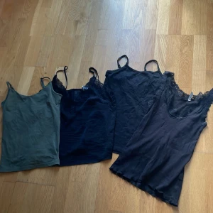 Fyra st linnen! - Säljer fyra linne-toppar i olika färger, tre svarta med tunna axelband och spets vid ringningen samt en olivgrön utan spets. Perfekta att styla lager på lager eller till jeans. Hör av er vid frågor!✨