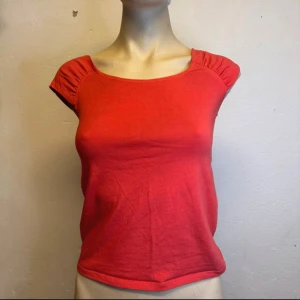 Korallröd topp från Bik Bok – puffärm & Y2K-känsla - Small:36 - Toppskick  - Figurnära topp från Bik Bok i varm korallröd nyans. Puffärmar och båtringning ger en feminin siluett med tydlig Y2K-känsla. Tillverkad i mjuk bomull med stretch – bekväm och snygg till jeans, kjol eller shorts. Märkt storlek S, passar även XS beroende på passform. I nyskick utan synliga spår av användning. Priset är redan lågt – jag prutar inte, men ger gärna rabatt vid köp av flera plagg. Jag rensar garderoben – kika gärna på mina andra annonser också!  ⸻  