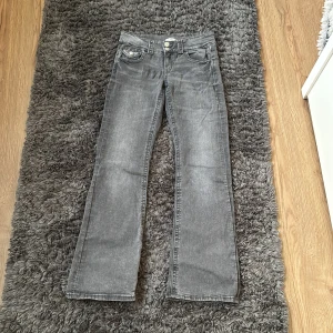 Grå bootcut lowwaste jeans med låg midja - Snygga grå jeans med bootcut-modell och låg midja. Klassisk femficksdesign och cool tvättad look. Perfekta för dig som gillar en avslappnad men trendig stil.