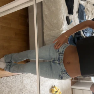 Ljusblå bootcut jeans - Säljer ett par ljusblå jeans med bootcut passform och låg midja. Jeansen har klassiska fickor både fram och bak och är tillverkade i mjukt denimtyg. Perfekta för en avslappnad och trendig look.