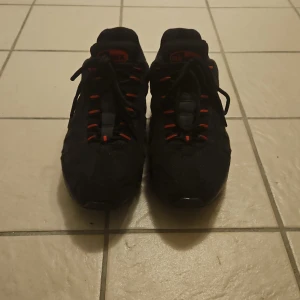 Nike Air Max 95 svarta sneakers med reflex - Svarta Nike Air Max sneakers med röda detaljer och snörning I storlek 42 dom är andvända men det är intr så tydligt.