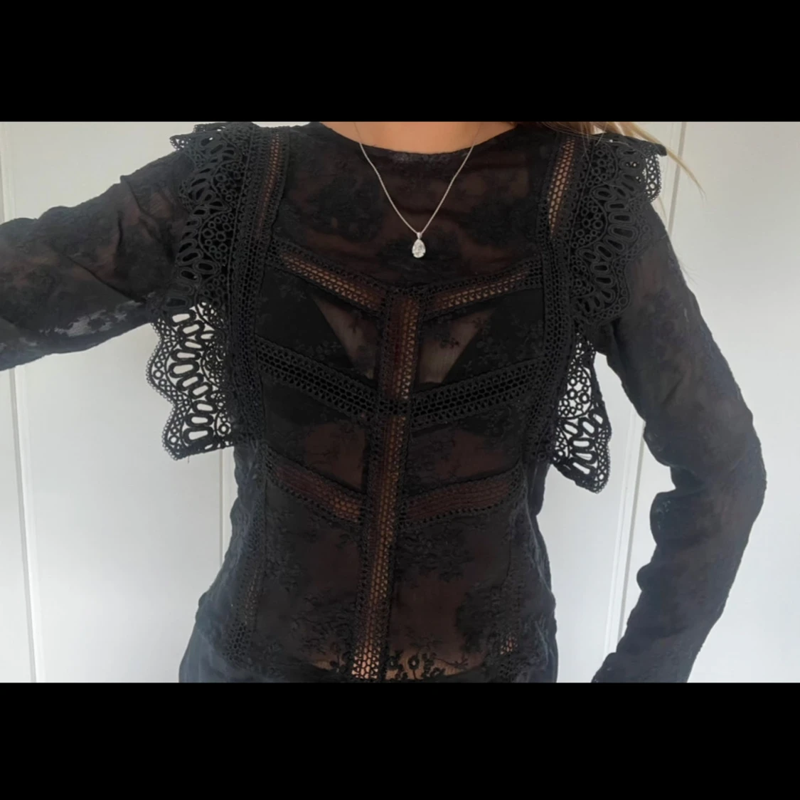 Svart spetsblus med volangdetaljer