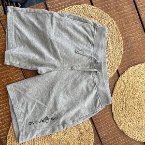 Grå shorts från Sail Racing med snörning - Snygga grå shorts från Sail Racing med mjuk bomullskänsla och bekväm midja med snörning. De har två sidofickor och en bakficka, samt logga tryckt på ena benet. 